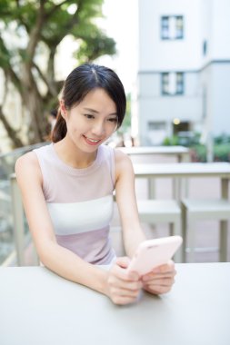 Açık café'de akıllı telefon kullanan kadın