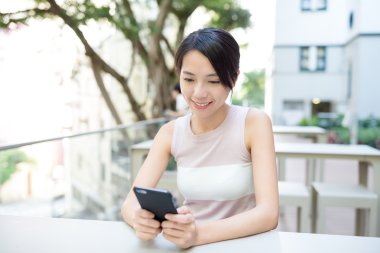 Açık café'de akıllı telefon kullanan kadın