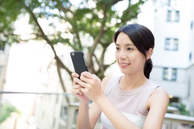 Açık café'de akıllı telefon kullanan kadın