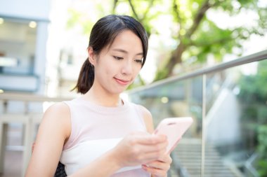 Açık café'de akıllı telefon kullanan kadın