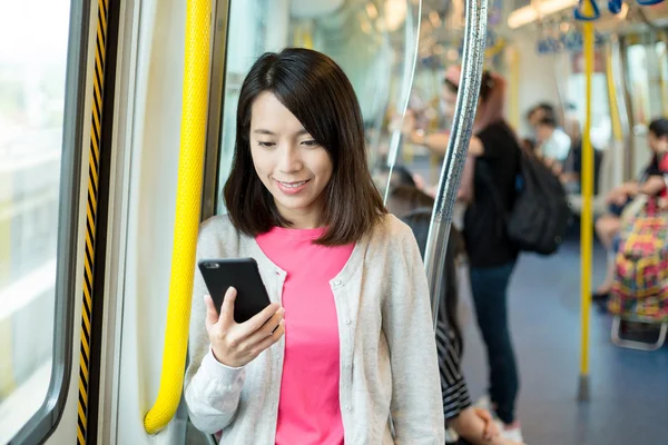 Žena použití mobilního telefonu uvnitř vlaku — Stock fotografie