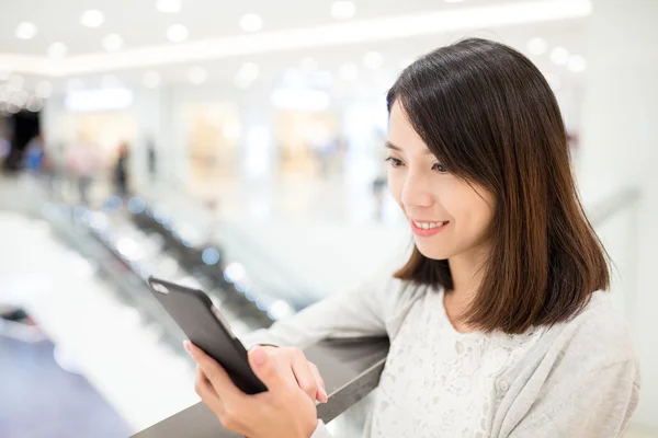 Vrouw met behulp van de mobiele telefoon bij winkelcentrum — Stockfoto