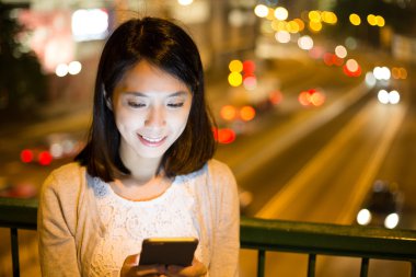 Geceleri cep telefonu kullanan kadın