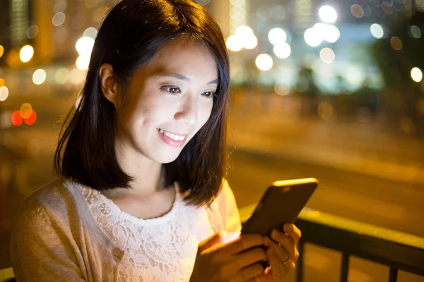 Vrouw met behulp van mobiele telefoon in de nacht — Stockfoto