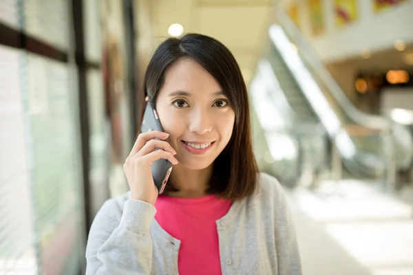 Kvinnan talar på mobiltelefon på köpcentrum — Stockfoto