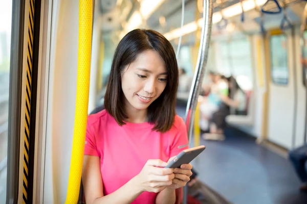 Nő vonat belsejében mobiltelefon segítségével — Stock Fotó