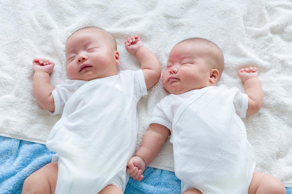 Twins lying on bed and sleeping