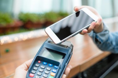 Fatura ödeme için cep telefonu kullanan kadın