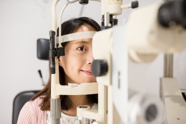 Ophthalmoscope içinde arayan kadın