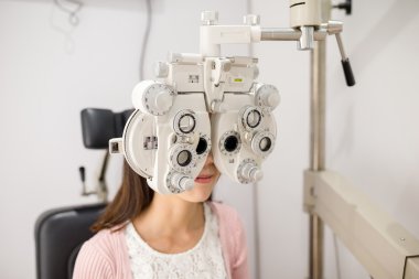 Ophthalmoscope içinde arayan kadın