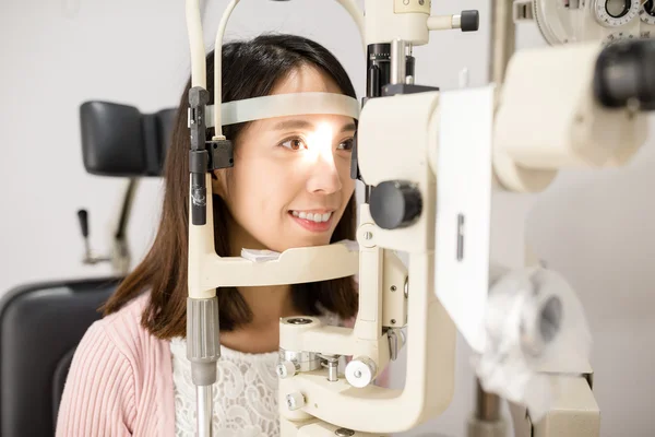 Женщина смотрит в офтальмоскоп — стоковое фото