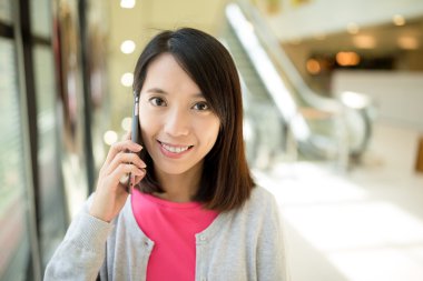 Kadın cep telefonuyla konuşuyor. 