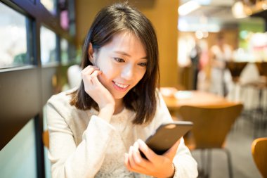 kahve dükkanında cep telefonu kullanan kadın