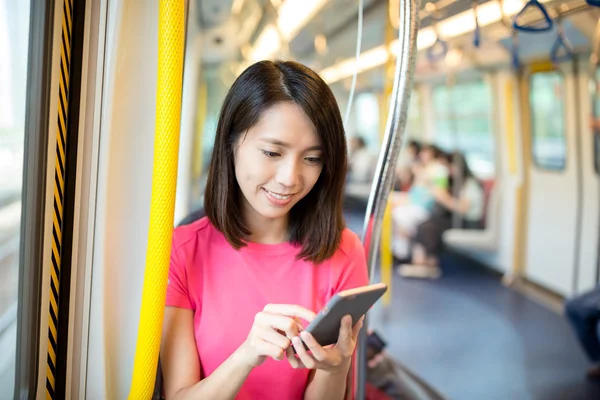 Mujer usando teléfono móvil dentro del tren — Foto de Stock
