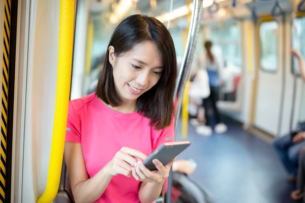 Žena použití mobilního telefonu uvnitř vlaku — Stock fotografie