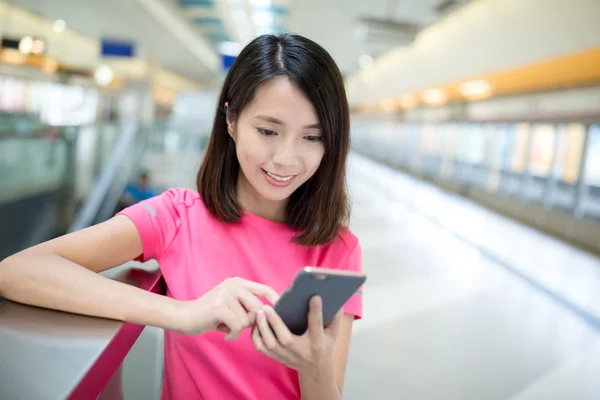 Femme utilisant un téléphone portable à la gare — Photo