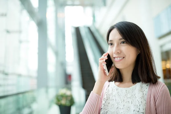 Kvinna som chattar på mobiltelefon på köpcentrum — Stockfoto