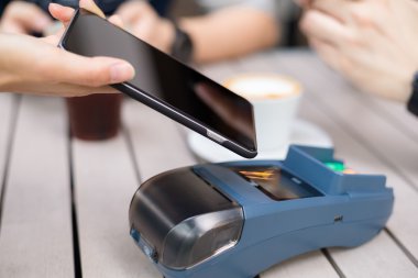 Fatura ödeme için cep telefonu kullanan kadın