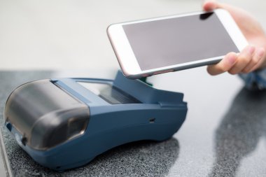 Fatura ödeme için cep telefonu kullanan kadın