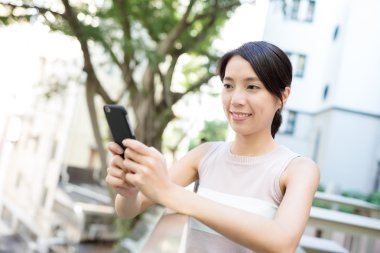 Açık café'de cep telefonu kullanan kadın