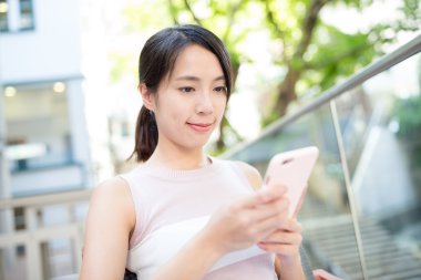 Açık café'de cep telefonu kullanan kadın