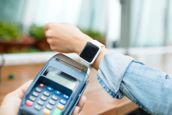 Mujer pagando la cuenta con un reloj inteligente — Foto de Stock