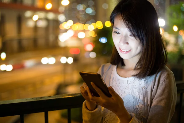 Mulher usando celular à noite — Fotografia de Stock