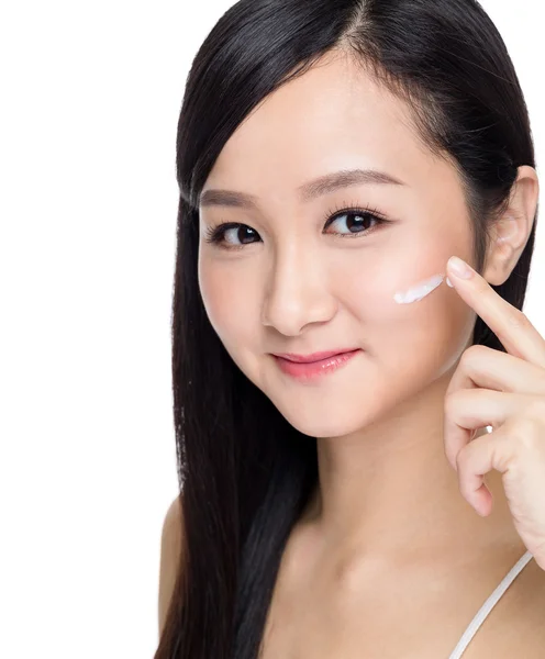Mujer aplicando crema cosmética — Foto de Stock