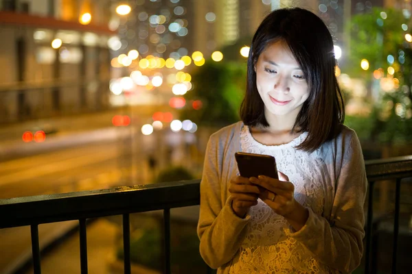 Kobieta korzystająca z telefonu komórkowego w nocy — Zdjęcie stockowe