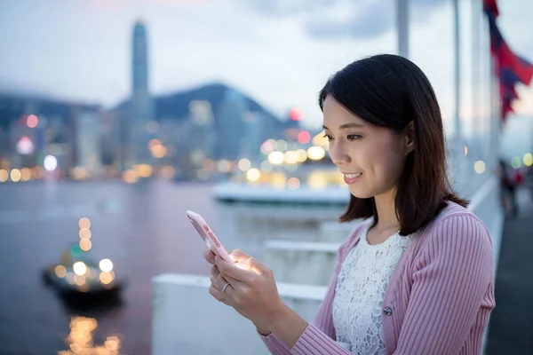 Mujer usando el teléfono celular al aire libre por la noche — Foto de Stock