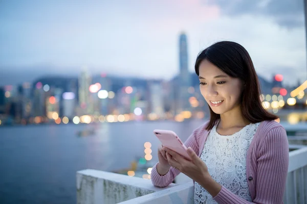 Mulher usando celular ao ar livre à noite — Fotografia de Stock