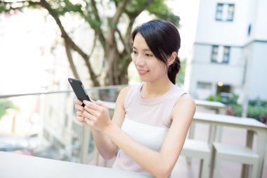 Açık café'de cep telefonu kullanan kadın