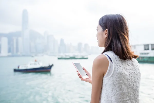 Mujer con teléfono celular mirando lejos —  Fotos de Stock