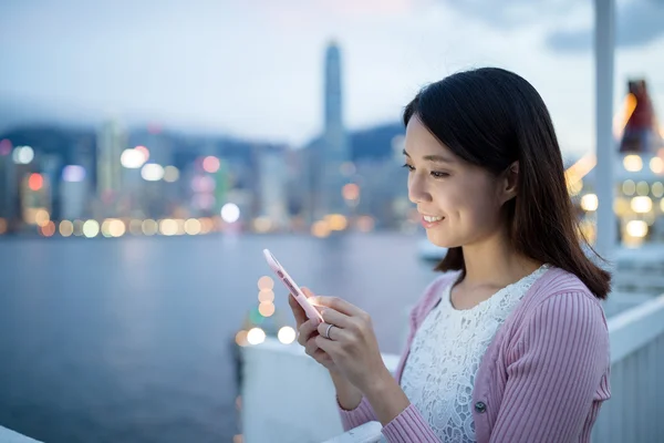 Mujer usando el teléfono móvil por la noche — Foto de Stock