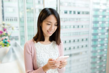 Alışveriş merkezinde akıllı telefon kullanan bir kadın.