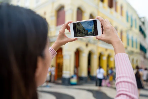 Женщина фотографирует по мобильному телефону в Макао — стоковое фото