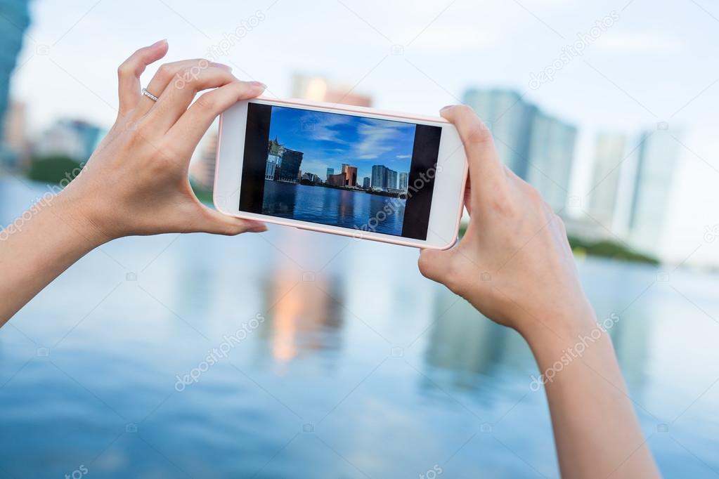 Hand taking photo on cellphone in Macau city