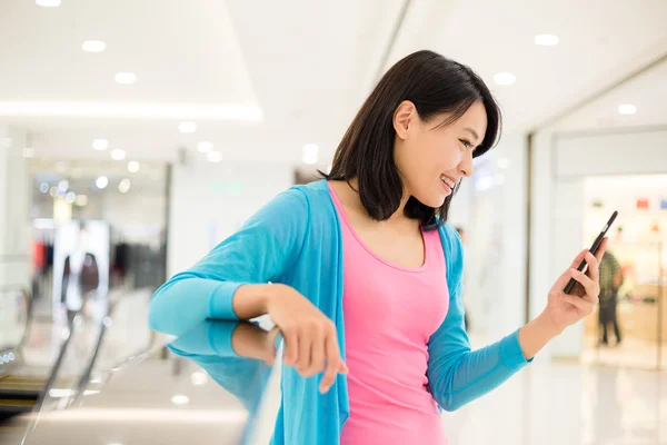 Vrouw met behulp van cellphone in winkelcentrum — Stockfoto