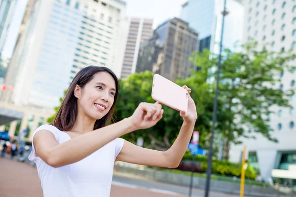 Vrouw met behulp van de mobiele telefoon om foto te nemen — Stockfoto