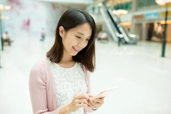 Kvinna med hjälp av mobiltelefon i köpcentrum — Stockfoto