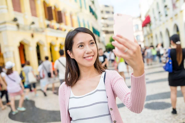 Kobieta, biorąc selfie przez telefon komórkowy w Makau — Zdjęcie stockowe