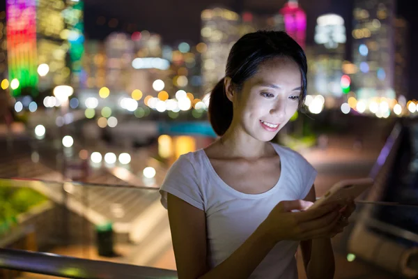 Mulher usando telefone celular à noite — Fotografia de Stock