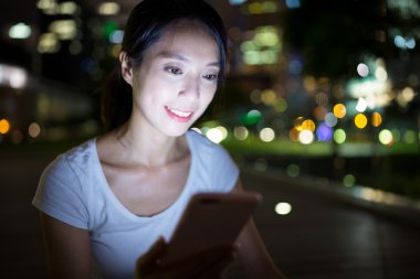 Geceleri cep telefonu kullanan kadın