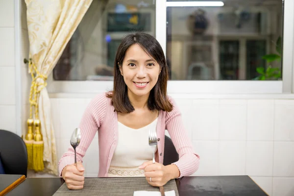 Жінка тримає ніж і виделку в ресторані — стокове фото