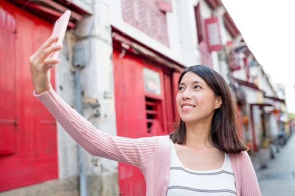 Vrouw met behulp van mobiele telefoon te nemen selfie — Stockfoto