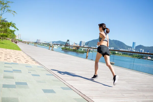 Mujer deportiva corriendo en el paseo marítimo — Foto de Stock