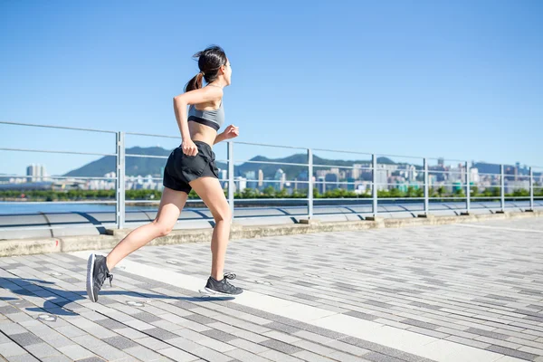 Mujer deportiva corriendo en el paseo marítimo — Foto de Stock