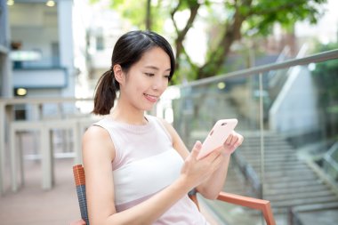 Açık café'de akıllı telefon kullanan kadın