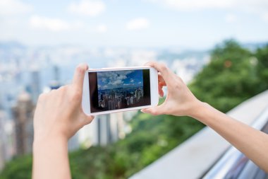 Hong Kong şehrinin fotoğraf çekmek için cep telefonu kullanan kadın
