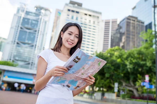 Woman looking for location on city map